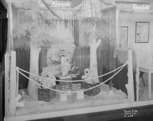 Left hand section of Kennedy-Mansfield Dairy Company booth at East Side Business Men's Association Fall Festival, featuring a winter landscape with three bears posed on ice cubes eating ice cream.