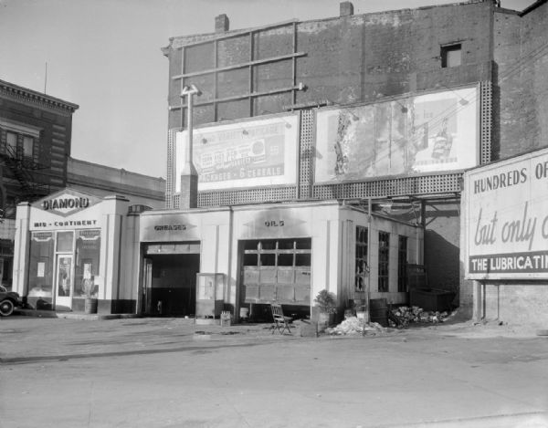 Burned-out Beran's D-X Diamond Mid-Continent Service Station, 118 King Street, at the corner of South Webster, including Kellogg's Cereal and Schlitz Beer billboards.
