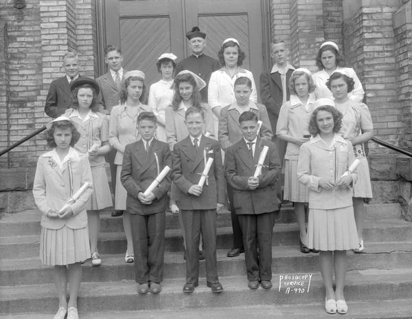 St. Patrick's Catholic Church Confirmation class and priest on the steps of St. Patrick's Churck at 410 East Main Street.