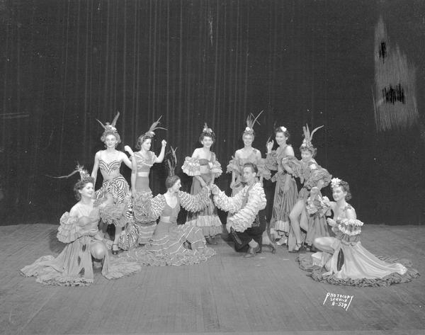 Scene from Truax Field's "Wac-Khaki" GI Revue: Rhumba dancers Pfcs. Mary Noonan and James Willingham, and eight other WACs as rhumba dancers, in costume, on stage.