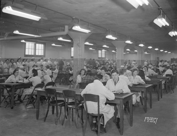 Oscar Mayer Company cafeteria, showing food line in the background on the far left, and workers sitting at tables in the foreground.