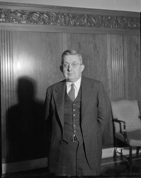 Portrait of Eugene Schwenkert, teller at the West Branch of the First Wisconsin Bank, 905 University Avenue, taken for the Ralph Timmons Advertising Agency.