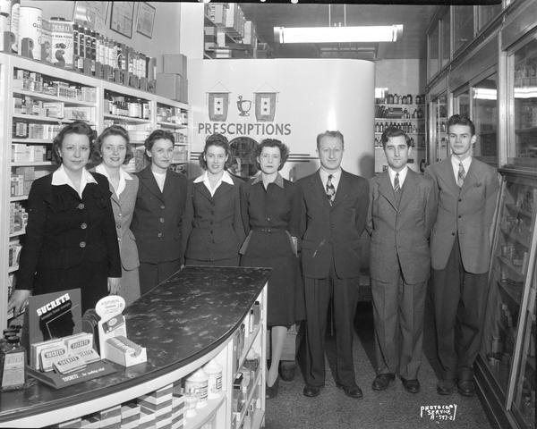 Prescription Pharmacy at 20 South Carroll Street, interior view. Employees group posing for Christmas card photograph, Samuel R. Chechik, Pharmacist.