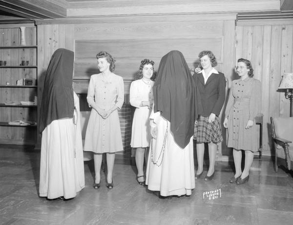 Four girls standing in a receiving line shaking hands with two nuns, in the recereation room in Marshall Hall, Edgewood High School, 1000 Edgewood Avenue.