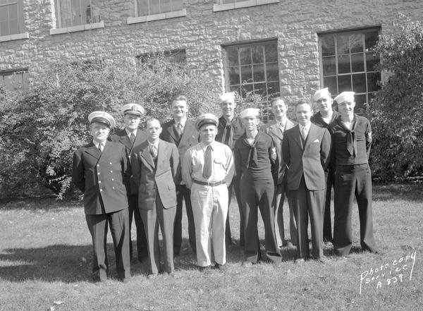 Group portrait of 11 U.S. Naval Training School (Radio) personnel: three officers, four non-commissioned sailors,and four male civilians on the University of Wisconsin-Madison campus. First man on the left is Elmer C. Zindars.