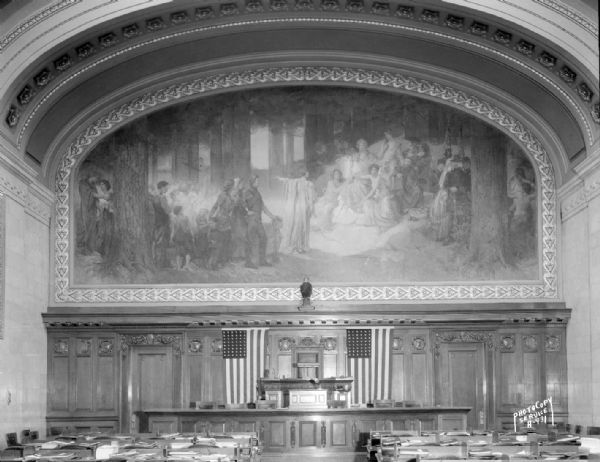 Wisconsin State Capitol Assembly Chamber mural, "The State of Wisconsin, its Past, Present, and Future," by Edwin Blashfield. Also shows Speaker's podium and a reproduction of Old Abe.