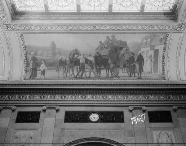 Colonial period travel by stagecoach which is halted at an inn and the horses are being changed, some of the passengers are getting off, one of four murals by Charles Yardley Turner representing the evolution of transportation in America, and part of the stained glass skylight in the Wisconsin State Capitol North Hearing Room.