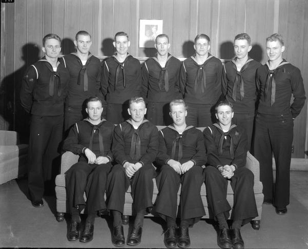Group portrait of 11 Unites States Navy sailors posing in the Rose Taylor Room in Kronshage Hall on the University of Wisconsin campus.