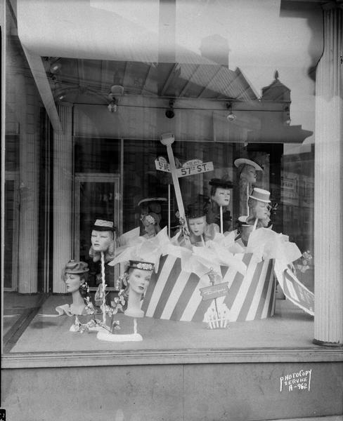 Hills Department Store, 202 State Street, women's hat display window taken from Dayton Street, with Yost's Department store reflected in the window.