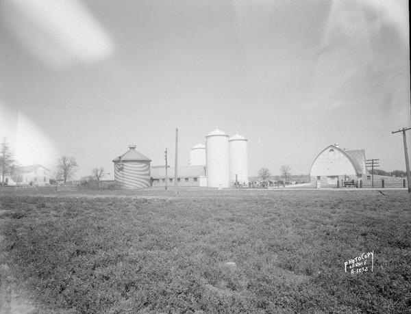 Wisconsin Conference of Seventh Day Adventists farm with cows and buildings including farmhouse, barn, three silos and a corn crib on Duborg Road off of Highway 16 west of Columbus, Wisconsin.