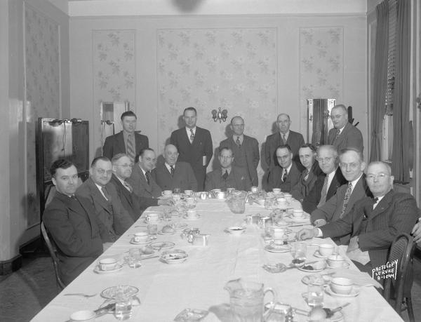 Farm Bureau Mutual Insurance group of sixteen men sitting at a luncheon table in the Wingra Room of the Park Hotel, 22 South Carroll Street.