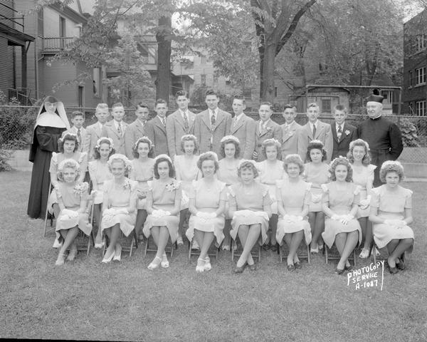 Outdoor group portrait of graduation class, Holy Redeemer School, 140 West Johnson Street, with priest and nun.