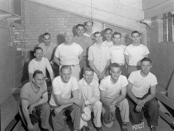 Group portrait of Knights of Columbus softball team showing fourteen men out of uniform. 