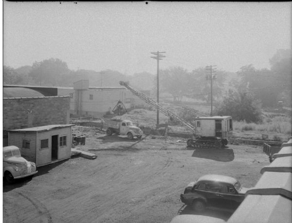 Elevated view of a Findorff truck and earthmover standing ready to excavate for an addition to the Red Dot Foods Incorporated potato chip factory, 1441 East Washington Avenue.