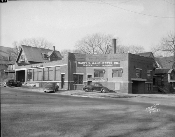 Exterior view of Manchester Service Building and Hinkson Advertising Co. signs, 412-418 East Washington Avenue. Also known as Gillespie Motor Sales, Madison Steam Dye and Klinke Cleaners.
