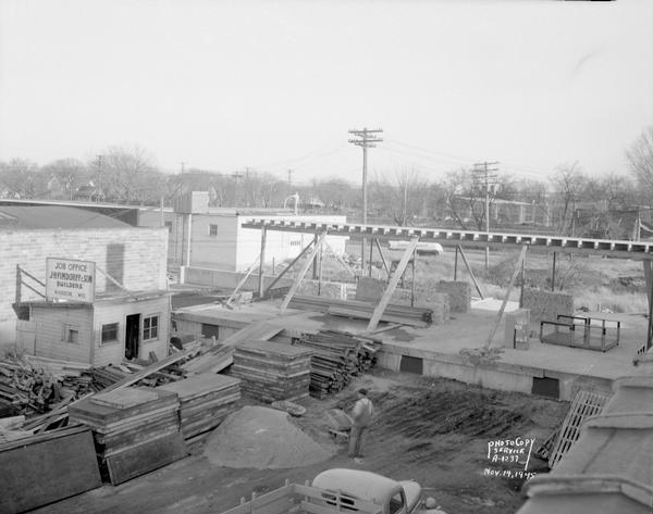 Elevated view of Red Dot Foods, Inc., construction project, new addition, 1441 East Washington Avenue. Shows Job Office, J.H. Findorff & Son Builders, and one workman.