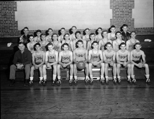 Group portrait of Edgewood High School male basketball squad in gymnasium.