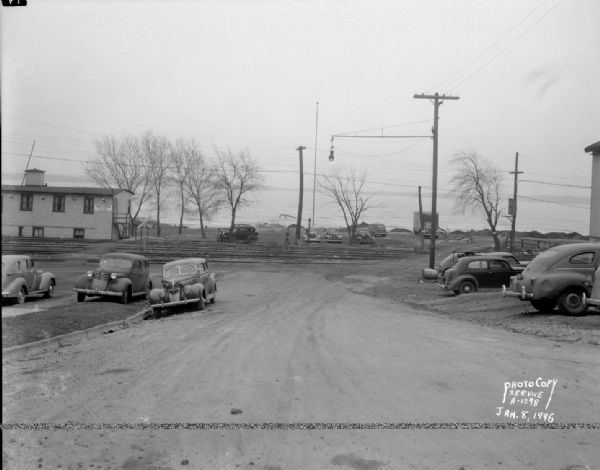 South Hancock Street scene looking South down unpaved South Hancock Street at the corner of East Wilson Street, taken at site of Reynolds Bus accident. Business shown is the Four Lakes Boat Club at 1 South Hancock Street. Lake Monona is in the background.