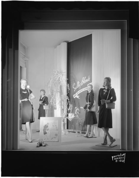 Four blonde mannequins in Manchester's, Inc., window, modeling dresses, purses, and shoes. "Sultry Blonde," Town and Country Company.