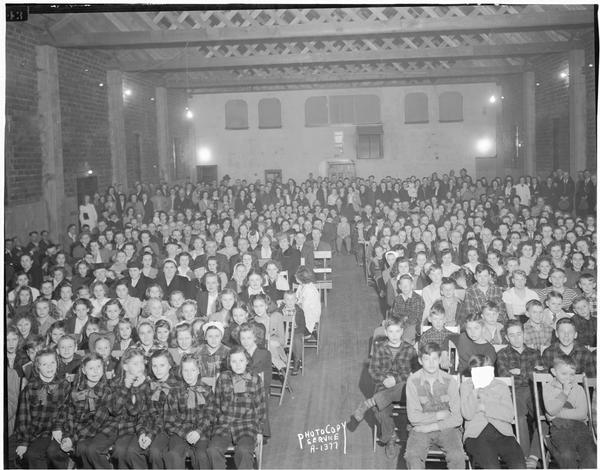 Audience at Smitty's Hall, Waunakee, for the grand opening program sponsored by the Milwaukee Cheese Company, which opened a new cheese plant on April 1st.