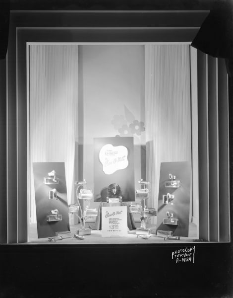 Window display at Harry S. Manchester's, Inc., 2-6 East Mifflin Street, featuring the "Can-o-mat" can openers, "Can-o-mat, fully automatic, streamlined beauty, fully enclosed, sealed in oil, 5 yr. guarantee. $3.98."