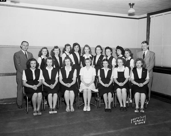 Group portrait of sixteen young women employees of Kresge $1.00 Store, 13 South Pinckney Street, in their new uniforms. Also includes two men in suits.