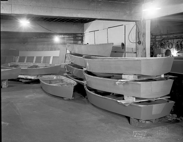 Ten row boats in storage inside a building at Inland Lakes Boat Works, 1501 Monroe Street.