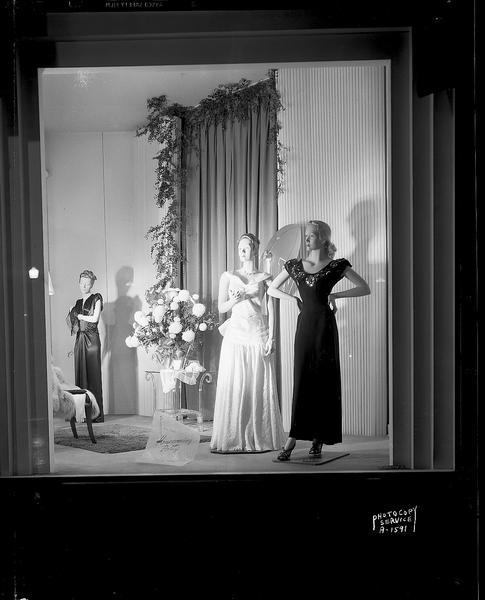 Manchester's University of Wisconsin homecoming window display showing three female mannequins wearing formal dresses.