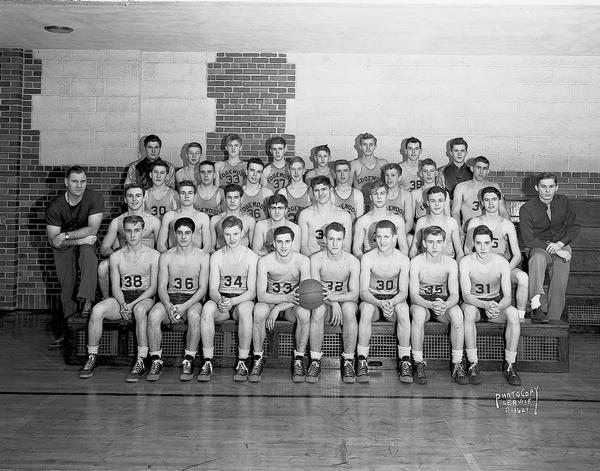 Group portrait of male basketball team at Edgewood High School. Two men are posing with the team.