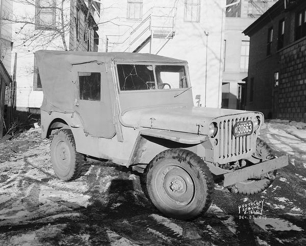 Damaged Jeep parked outdoors. The Jeep was driven by William Rigney when he struck and killed John Milen near the White Manor Tavern, 2201 N. Sherman Avenue.