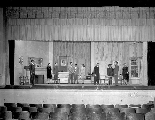 Madison Theatre Guild play on stage at West High School, 30 Ash Street, showing stage setting for "Mr. and Mrs. North," with seven actors and three actresses.