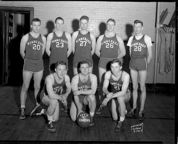 Group portrait of the Winnebago Auto Repair company basketball team in uniform, the City champions of 1947. Three men are kneeling in the front row.