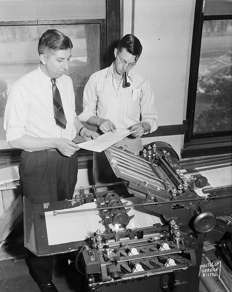 Credit Union National Association <i>Bridge</i> magazine, 1342 East Washington Avenue, showing two men with the folding machine.