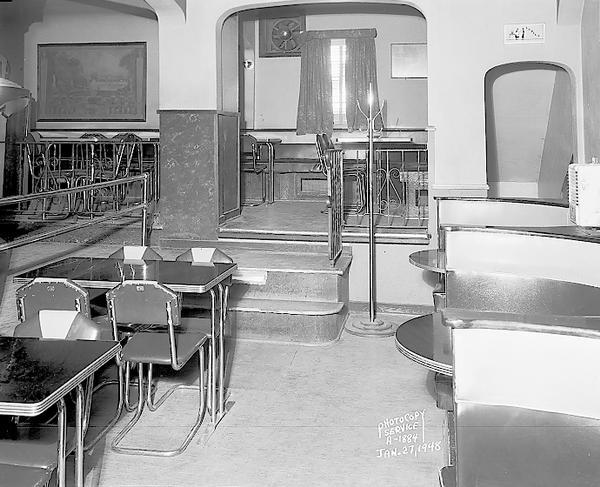 Spanish Village Club, 1718 Commercial Avenue, interior, showing Art Deco table and chairs and booths in front of steps up to platform in the rear of the tavern.