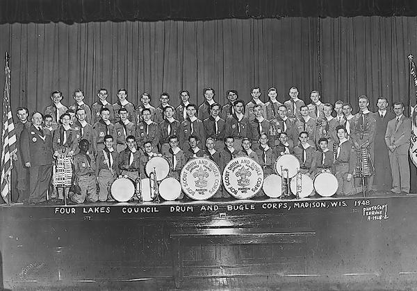 Group portrait of Madison Boy Scout Drum & Bugle Corps taken on the Central High School stage, including drums and bugles. Caption added to the negative reads: "Four Lakes Council Drum & Bugle Corps, Madison, Wis. 1948."