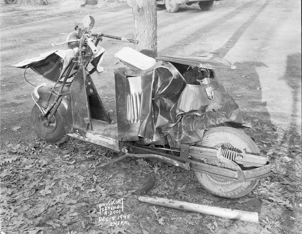 Damaged Cushman motor scooter, taken for General Casualty Company. Thomas A. Gallagher, age 18, was killed when struck by a car while riding the scooter on Highway 12-18 near the entrance to Club Hollywood.