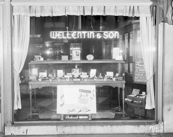 Store window of Wellentin & Sons, Jewelers, 122 West Washington Avenue, featuring "Boulevard Watches" and their WKOW radio program.