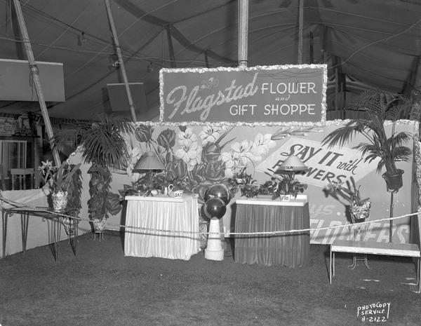 Flagstad Flower and Gift Shoppe, display booth in a tent at East Side Business Men's Association Fall Festival in Olbrich Park, with plants.