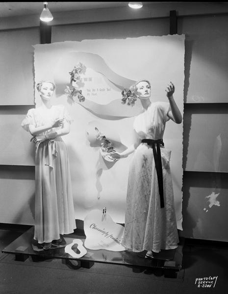 A foyer display at Manchester's, Inc., 2 East Mifflin Street, featuring two mannequins wearing pink dresses. A sign reads: "If you like pink, you are a gentle soul at heart."