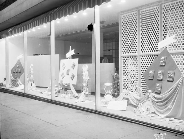 A window display at Manchester's, Inc., 2 East Mifflin Street, close-up taken at an angle, featuring Wallace, International and Lunt sterling silverware.