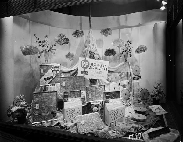 Research Products Company display window at Wolff-Kubly & Hirsig Hardware Store, featuring Filter-Fry frying pan cover and E Z Kleen air filters.