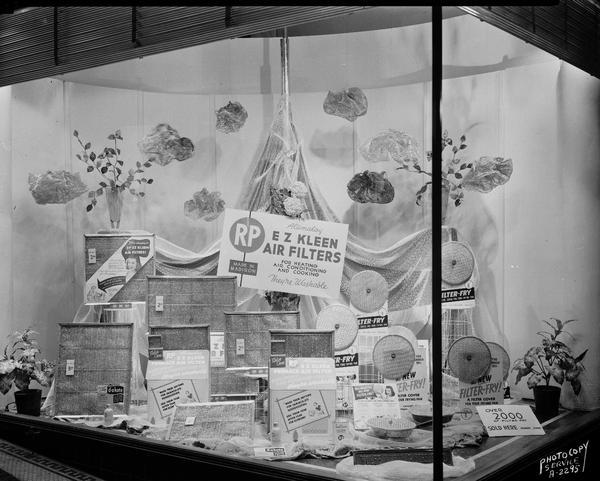 Research Products Company display window at Wolff Kubly & Hirsig Hardware Store, featuring Filter-Fry frying pan cover and E Z Kleen air filters.