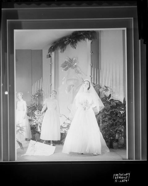 Manchester's, Inc., bridal window display, featuring three mannequins wearing wedding attire.
