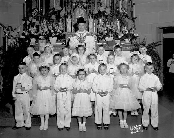 A group portrait of a First Communion class, taken in front of the altar at St. Peter Catholic Church.