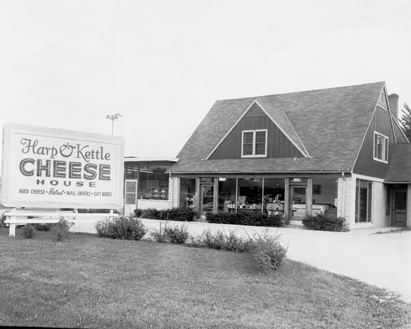 Close-up of the Harp and Kettle Cheese House drive-in restaurant and store with roadside sign advertising "Aged Cheese, Retail, Mail Orders, Gift Boxes."