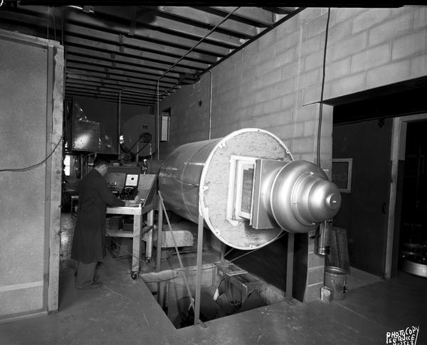 Man operating a ventilator testing cylinder at W.R. Carnes Company.