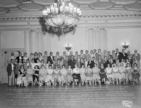 Group portrait of West High School class of 1936 reunion at the Loraine Hotel Crystal Ballroom, with list of names on separate negative.