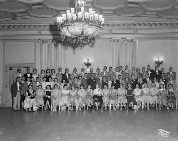Group portrait of West High School class of 1936 reunion at the Loraine Hotel Crystal Ballroom, with list of names on separate negative, alternate view.
