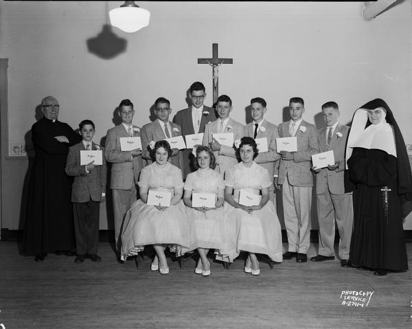 Group portrait of Holy Redeemer Catholic School graduation class, eight boys and three girls, with priest and nun.