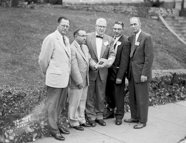 Group portrait of five men representing regional electic and telephone cooperatives attending a meeting at the Edgewater Hotel.